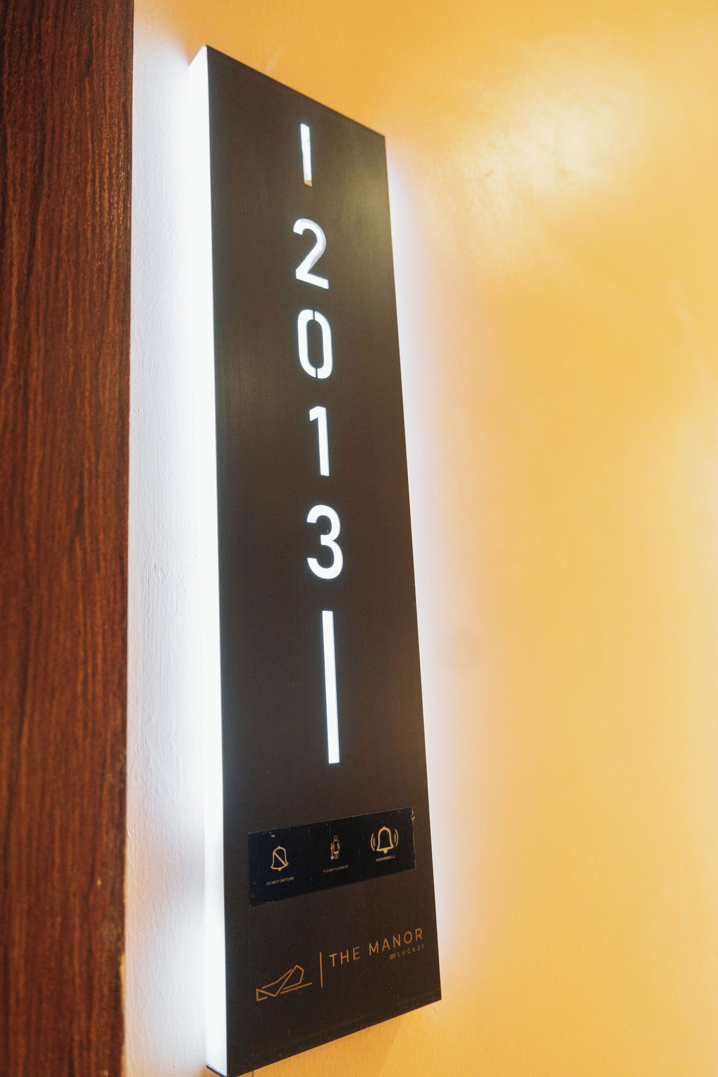 Un letrero negro con números blancos '12013' y un logotipo en la parte inferior.