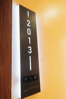 Un letrero negro con números blancos '12013' y un logotipo en la parte inferior.