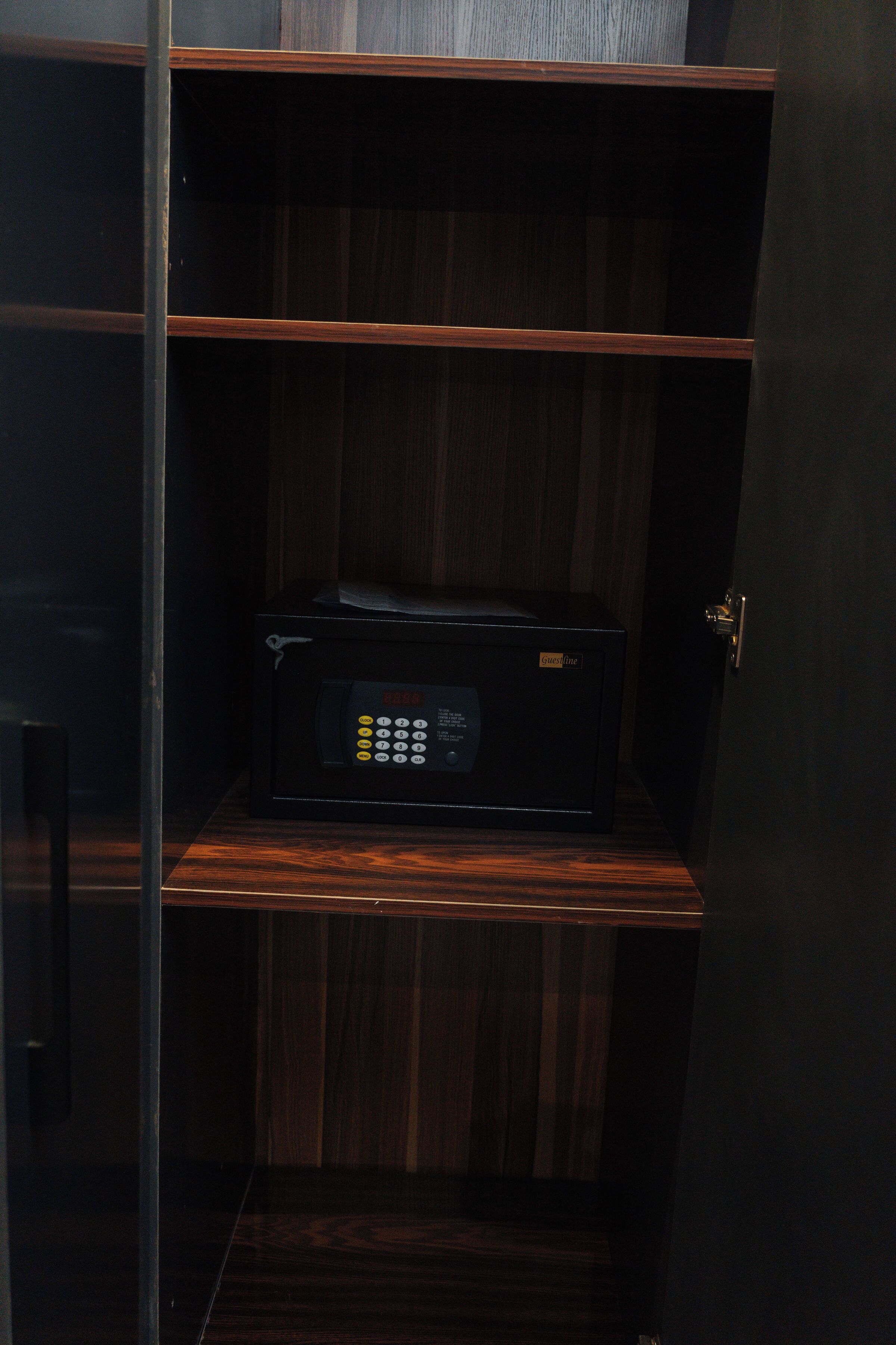 A microwave on a wooden shelf in a kitchen cabinet.