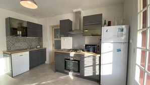 Een moderne keuken met een vaatwasser, oven, magnetron en een koelkast.