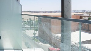 A modern interior with a large window offering a view of an airport and surrounding buildings. - Bloomfields New STU in Oasis Masdar City (Abu Dabi)
