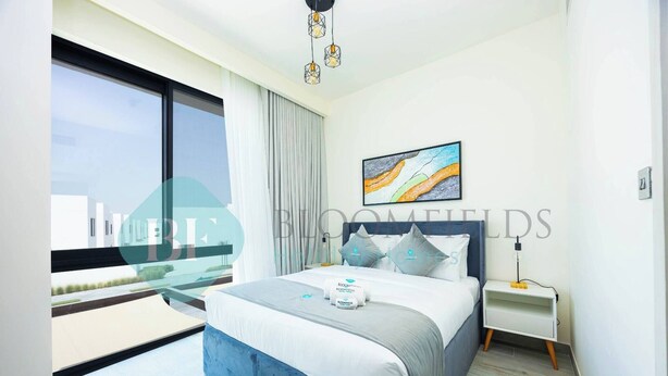Un dormitorio moderno con una cama grande, una mesita de noche, una lámpara de techo e iluminación junto a la cama, y una ventana con vistas.
