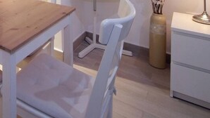 Ein kleiner Essbereich mit einem Holztisch und weißen Stühlen.