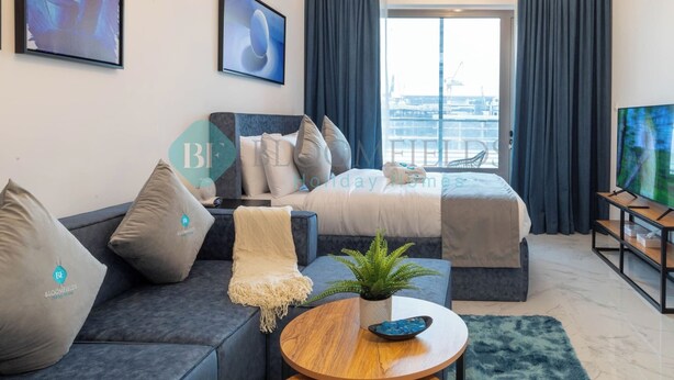Een moderne hotelkamer met een bed, een bank en een televisie.
