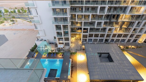 Un hôtel moderne doté d’une piscine sur le toit, de nombreux balcons et d’une cour spacieuse.