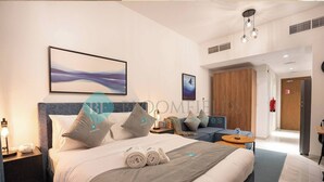 Une chambre d’hôtel moderne dotée d’un grand lit, d’un bureau et d’un coin salon.
