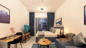 Une chambre d’hôtel moderne équipée d’un lit, d’un canapé, d’une table à manger et d’une petite table ronde.
