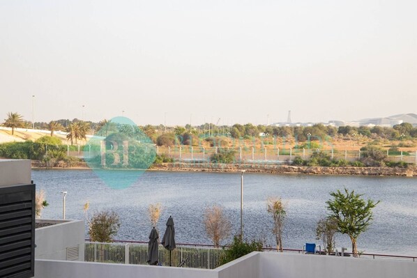 A view of a body of water with a distant landscape, including trees and buildings.