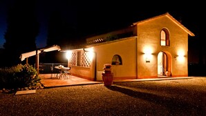 A building with a patio area, a table and chairs, and a potted plant. - Cottage - The Hill Below - Imagine a place just for you (Toscana)