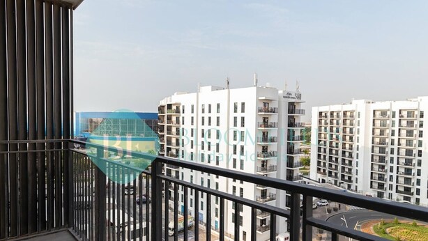 Ein Balkon mit Blick auf moderne Wohngebäude und einen Kreisverkehr.