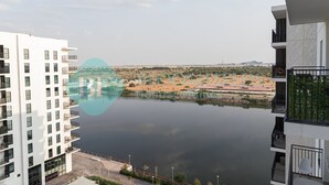 Ein modernes Gebäude mit Blick auf einen stillen See und eine entfernte Landschaft.