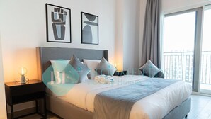 Ein modernes Schlafzimmer mit einem großen Bett, einem Nachttisch mit Lampe und Kunstwerken an der Wand.