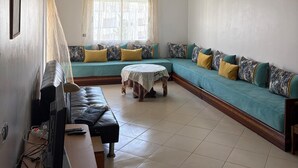 A living room with a sofa set, a television, and a table. - For rent: Luxury apartment in a tourist residence. (Asilah)