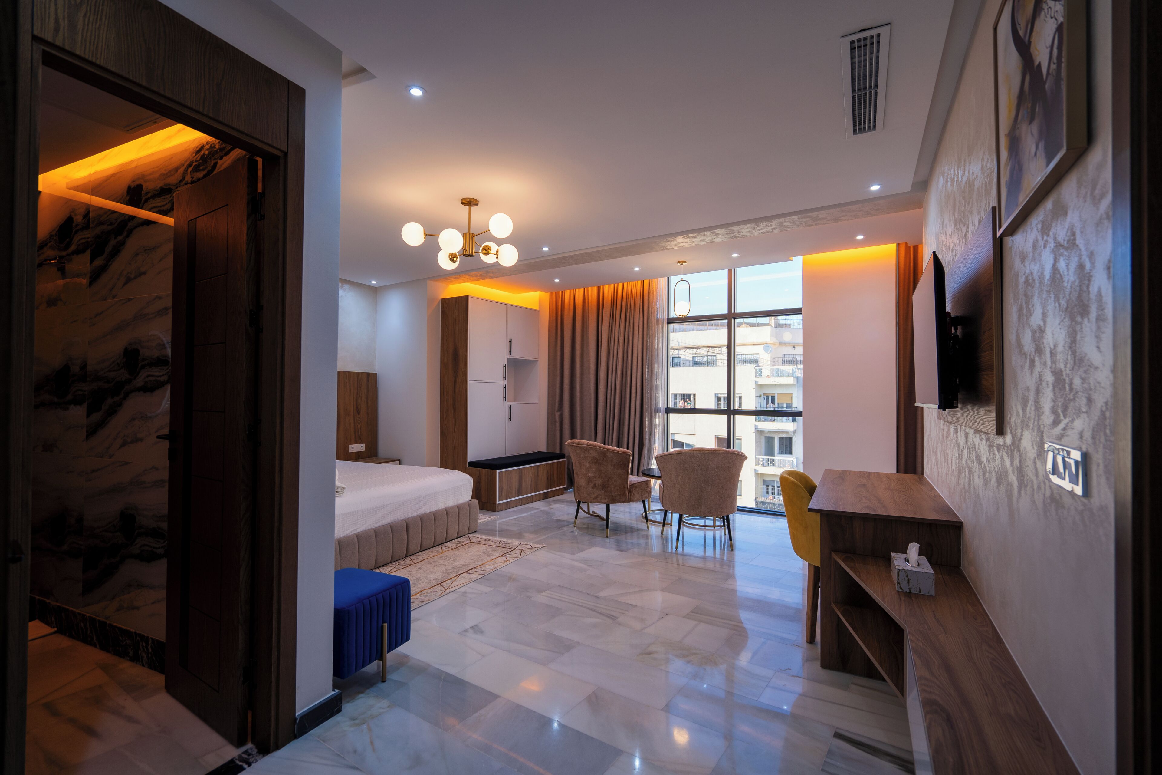 Une chambre d’hôtel moderne équipée d’un lit, d’un coin salon et d’un bureau.