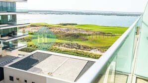 Un edificio moderno con terrazza sul tetto affacciato su un campo da golf e sull'acqua.