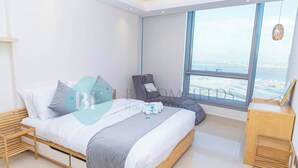 Una camera da letto moderna con un letto grande, una sedia, una scrivania e vista sulla città.