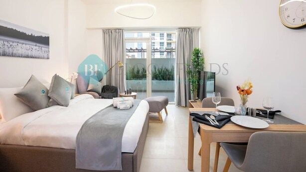 A modern hotel room with a bed, a desk with a chair, a dining table set for two, and a large window with curtains. - Bloomfields STU Farishta Alfurjan near Metro (Dubai)