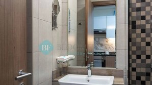 A modern bathroom with a large sink, a mirror, and a towel rack. - Bloomfields STU Farishta Alfurjan near Metro (Dubai)