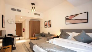 Ein modernes Hotelzimmer mit einem großen Bett, einem Schreibtisch, einer Sitzecke und einem Essbereich.