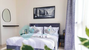 Quarto moderno com cama, almofadas, mesa de cabeceira, abajur e janela com cortinas.