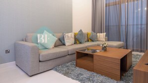 A modern living room with a grey sofa, a wooden coffee table, and a fluffy rug.