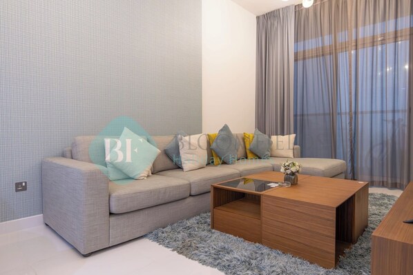 A modern living room with a grey sofa, a wooden coffee table, and a fluffy rug.