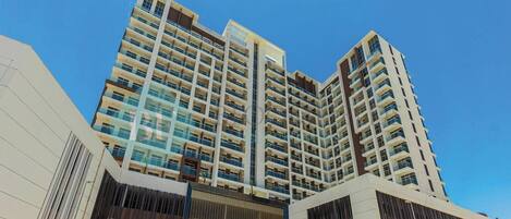 A high-rise building with multiple balconies and a modern architectural design.