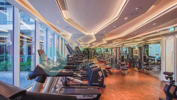 A modern gym with treadmills, weight machines, and mirrors. - Bloomfields Hidden Gem Studio In Arjan (Dubai)