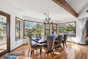 A dining room with a large table, six chairs, and a chandelier. - Hot tub, In-Home Bar, Arcade Game, Wood Fireplaces, Xbox, Grill, Sleeps up to 16 (Flagstaff)