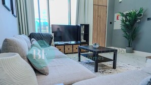 Una sala de estar moderna con un sofá, una mesa de centro y una televisión.
