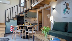 A modern kitchen with wooden cabinets and a dining area with a table and chairs. - Pure Nature (Hersonissos)