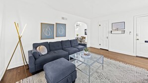A modern living room with a grey sofa, a glass coffee table, and a patterned rug. - Exclusive Louisville king suite near bourbon trail (Louisville)