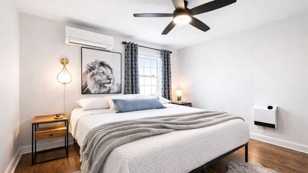 A modern bedroom with a bed, bedside tables, a ceiling fan, an air conditioning unit, and a window with curtains. - Exclusive Louisville king suite near bourbon trail (Louisville)