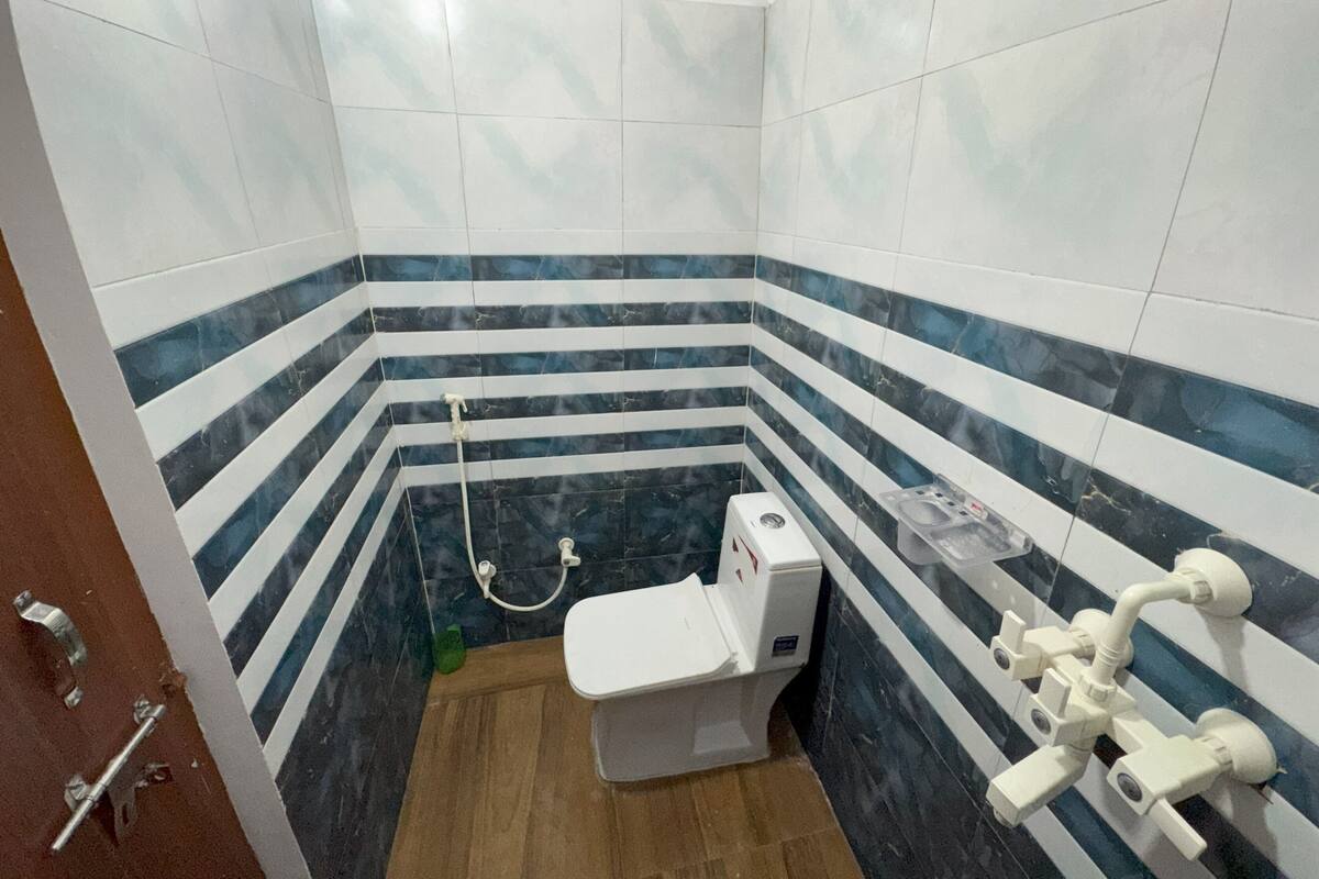 A small bathroom with a toilet, a shower, and a sink.