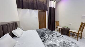 Ein Schlafzimmer mit einem Bett, einem Sessel, einem kleinen Tisch und einer Tür.