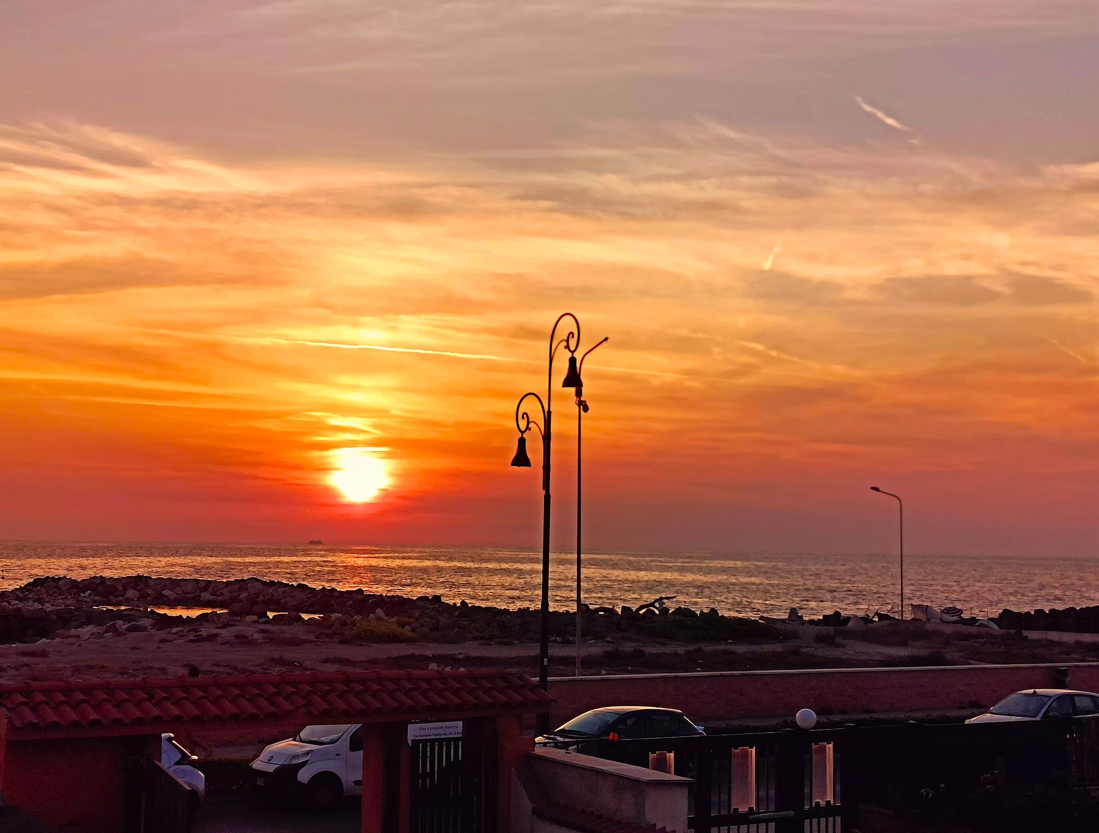 Un atardecer sobre una playa con un farol y un letrero que dice 'Primer Piso, Tercer Piso, Cuarto Piso'.
