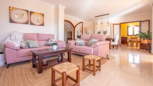 Ein geräumiges Wohnzimmer mit zwei Sofas, einem Couchtisch und einem kleinen Holzschemel.