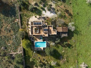 Vue aérienne d’une maison moderne dotée d’une piscine, de nombreuses pièces et d’un espace patio.