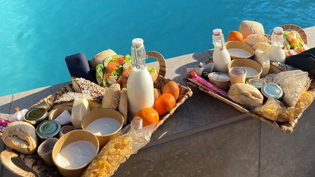 Esmorzar a la piscina amb diferents plats i begudes.