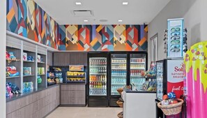 A snack bar with shelves stocked with snacks and beverages, a refrigerator with drinks, and a counter with a basket. - The Epic 10406 Paradiso Grande Resort Orlando Florida (Orlando)