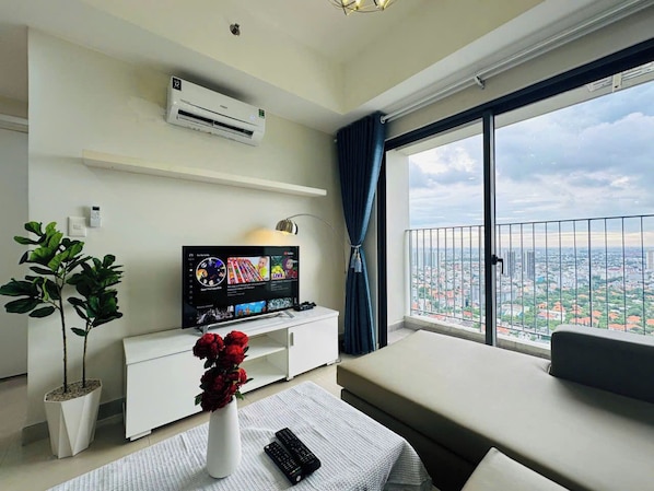 Luxury Apartment, City View | Living area | 60-inch flat-screen TV with cable channels - Masteri Thao Dien Apartment (Ho Chi Minh City)