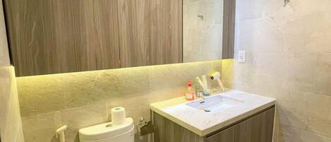 A modern bathroom with a toilet, sink, and shower.