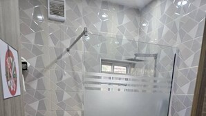 Une salle de bain équipée d’une douche, de toilettes et d’un lavabo.