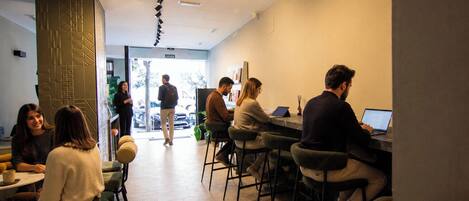 A modern interior with hexagonal flooring, bar stools, and a seating area with tables.