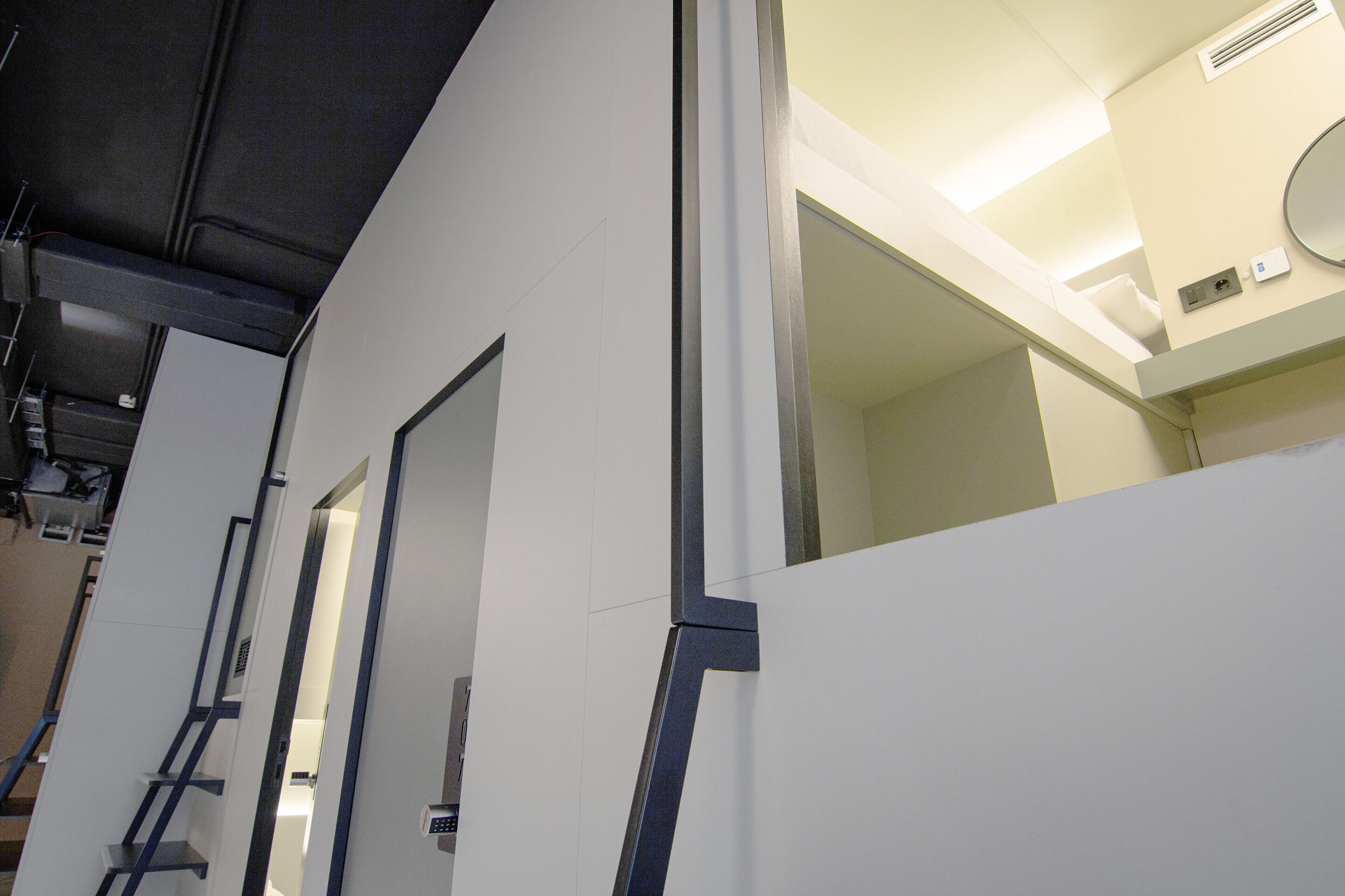 A modern interior with white walls, a visible door, and a ceiling with recessed lighting.