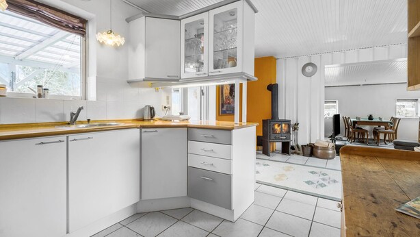 A modern kitchen with white cabinetry, a wooden countertop, and a built-in stove. - Lovely home in Grevinge with WiFi (Grevinge)