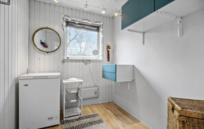 A compact, well-lit room with a white radiator, a small sink, a mirror, a window with a view of bare trees, and a wicker basket. - Lovely home in Grevinge with WiFi (Grevinge)