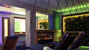 A room with two lounge chairs, a fireplace, and a view of the outdoors. - Hotel Birkenhof (Soelden)