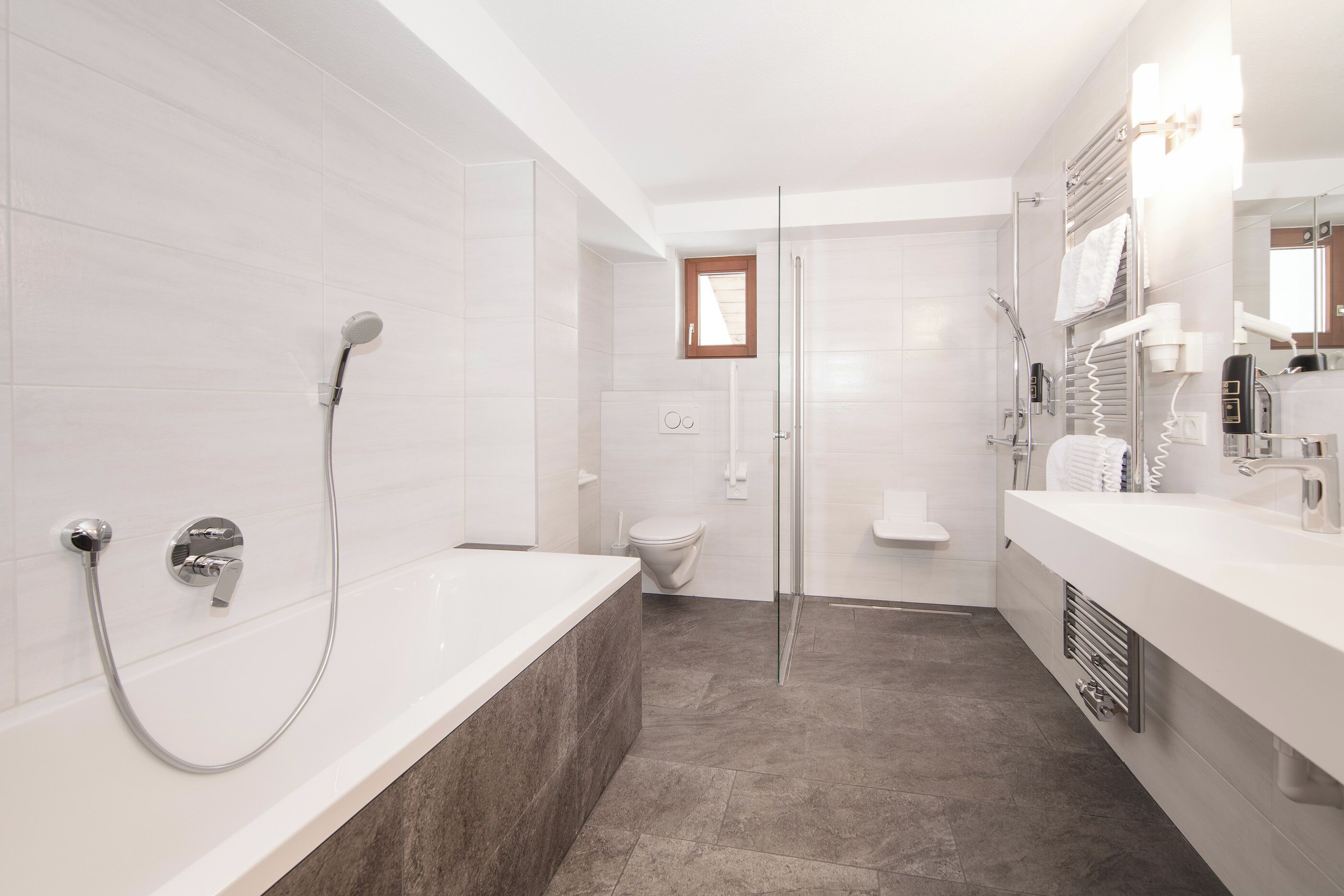 Un baño moderno con bañera, ducha e inodoro.