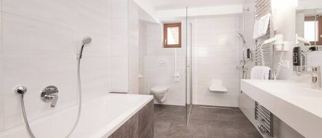 Un baño moderno con bañera, ducha e inodoro.